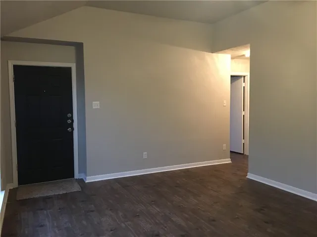 an empty room with wooden floor and closet