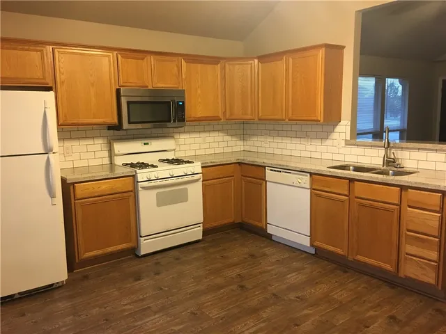 a kitchen with a sink white cabinets and white appliances