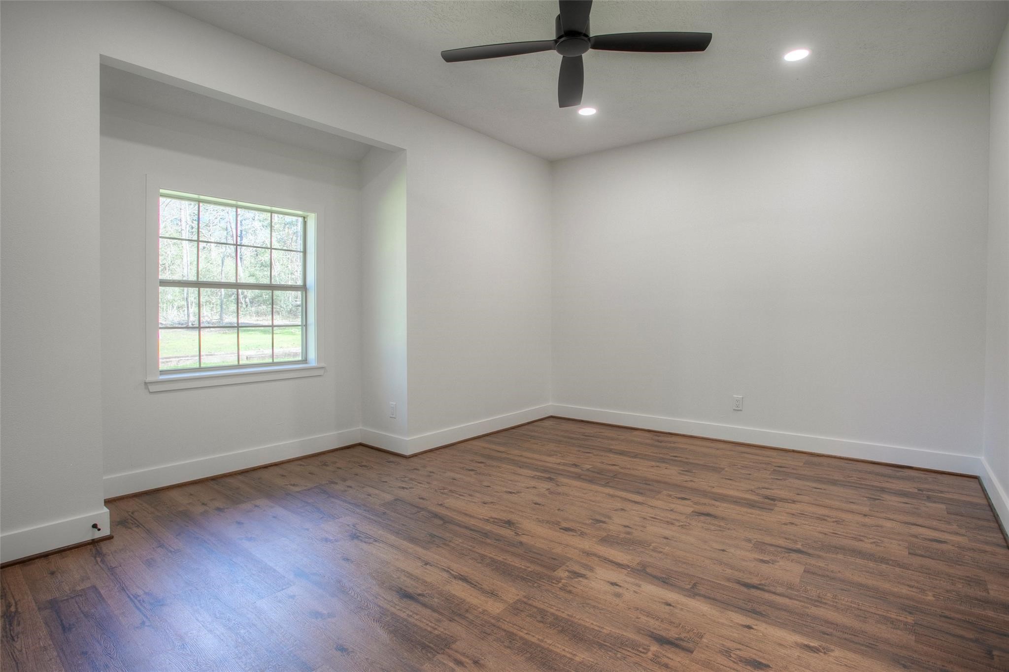 83 Dahlia Road Huntsville, TX 77320 - Photo 36 of 49 wooden floor in an empty room with a window