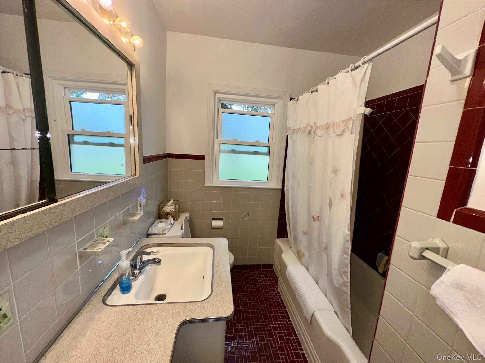 406 Moriches Road St. James, NY 11780 - Photo 17 of 28 a bathroom with a sink a mirror a bathtub and a shower