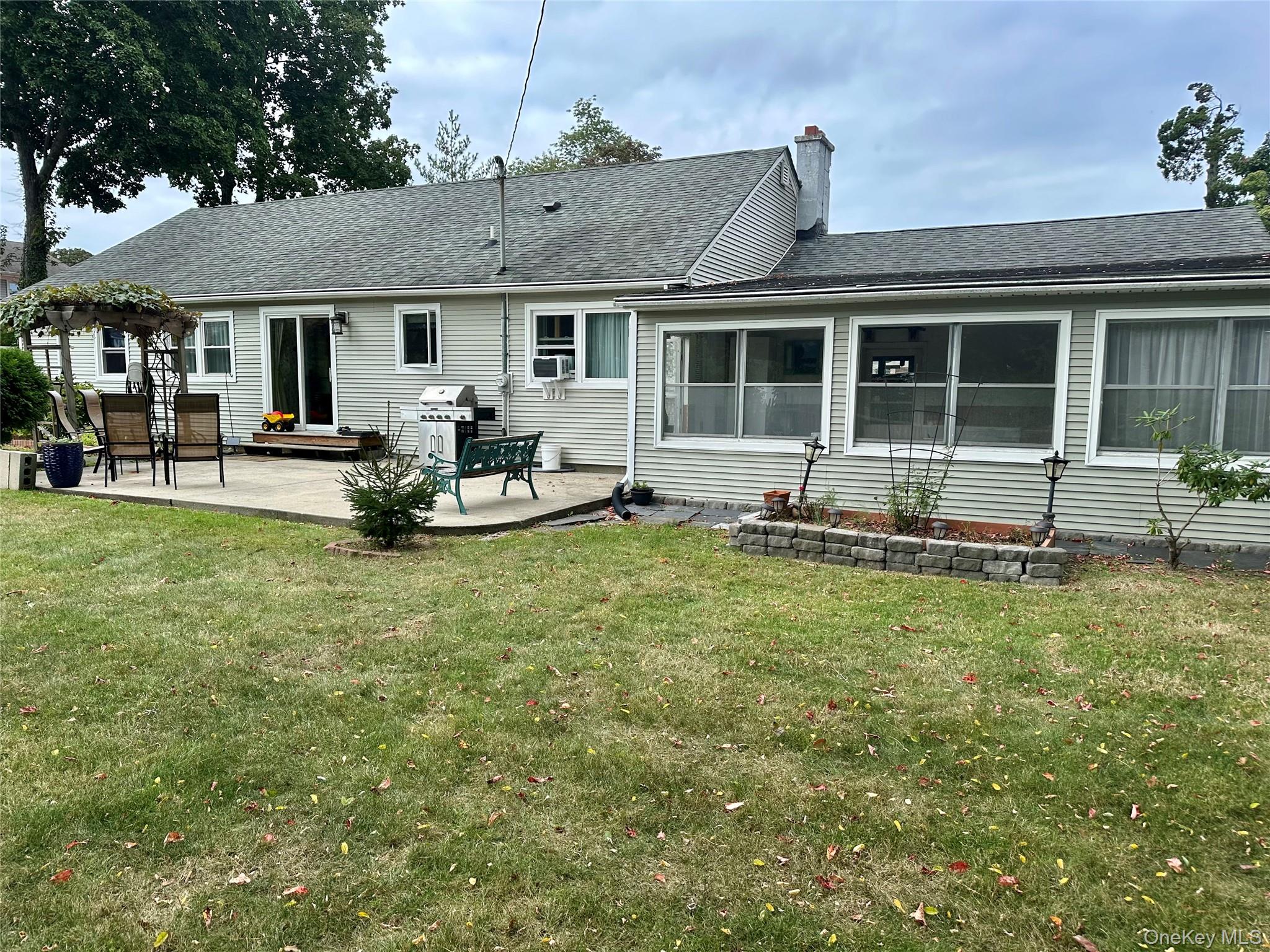 406 Moriches Road St. James, NY 11780 - Photo 24 of 28 a front view of a house with a garden and patio