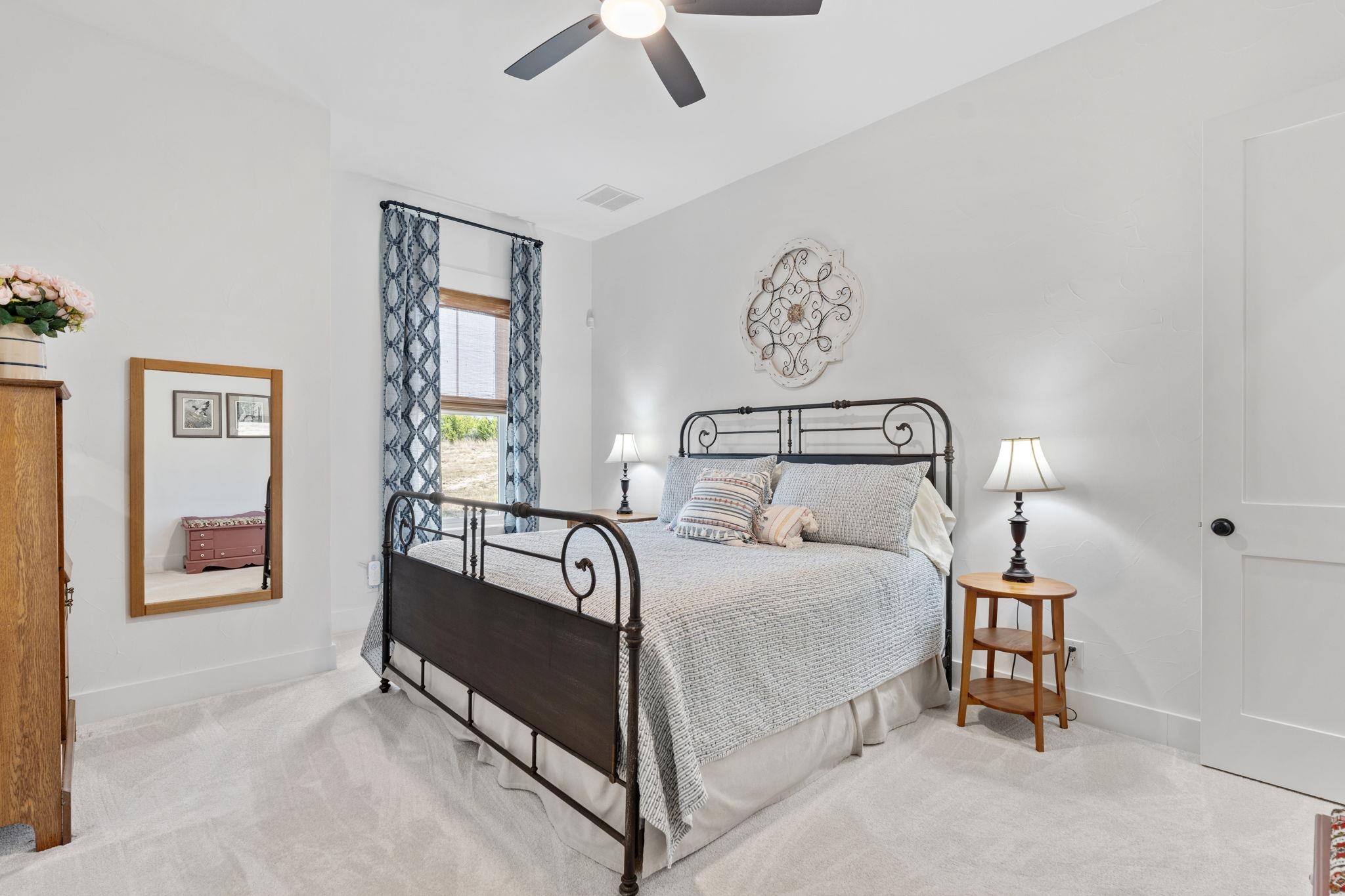 452 Southwick Ranch Road Johnson City, TX 78636 - Photo 17 of 44 a bedroom with a bed and a chandelier