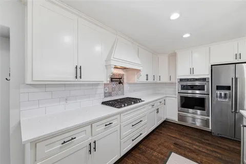 a kitchen with white cabinets and stainless steel appliances