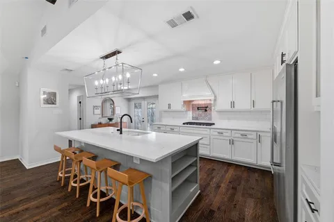 a large kitchen with kitchen island a sink table and chairs