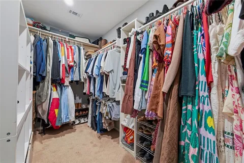 a view of walk in closet with clothes