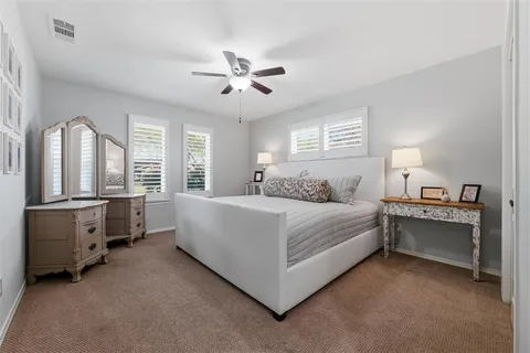 a spacious bedroom with a bed and a chandelier