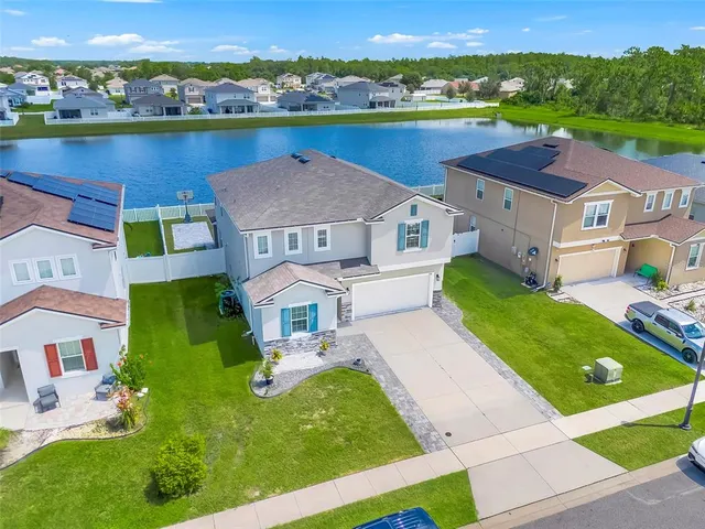 an aerial view of residential houses with outdoor space and river