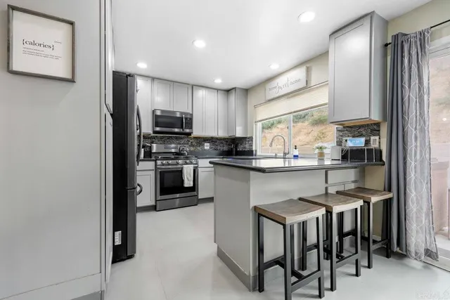a kitchen with kitchen island granite countertop wooden floor and stainless steel appliances