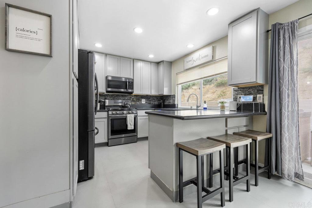a kitchen with kitchen island granite countertop wooden floor and stainless steel appliances