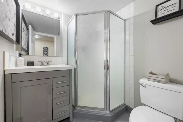 a bathroom with a sink a toilet and shower