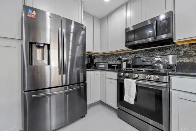 a metallic refrigerator freezer sitting in a kitchen