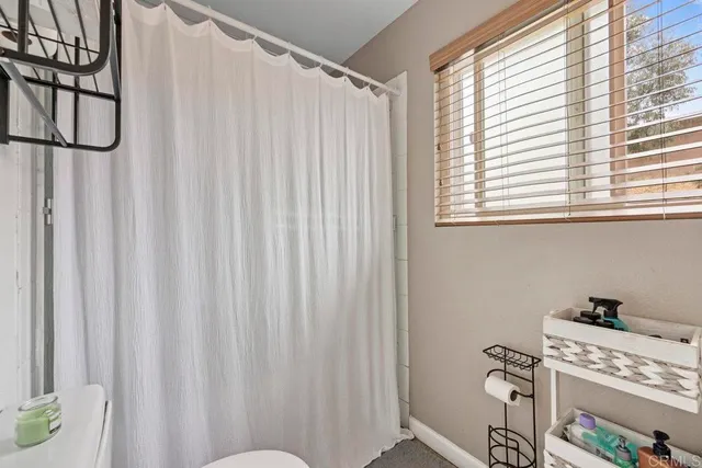 a bathroom with a window and a shower curtain