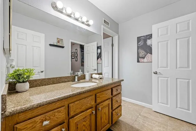 a bathroom with a granite countertop sink a mirror and vanity