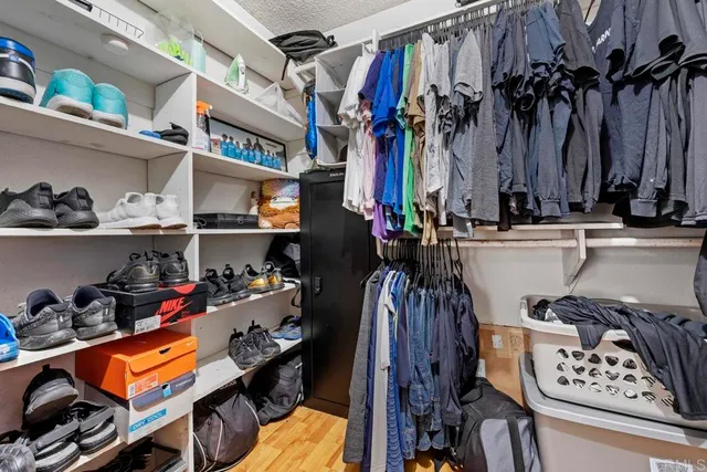 a view of walk in closet with clothes and shoes
