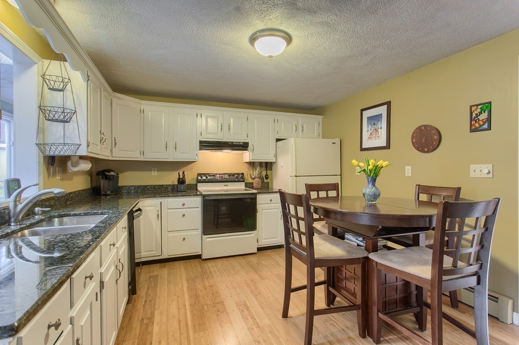 86 Squannacook Road Shirley, MA 01464 - Photo 6 of 30 a kitchen with a table chairs and a refrigerator