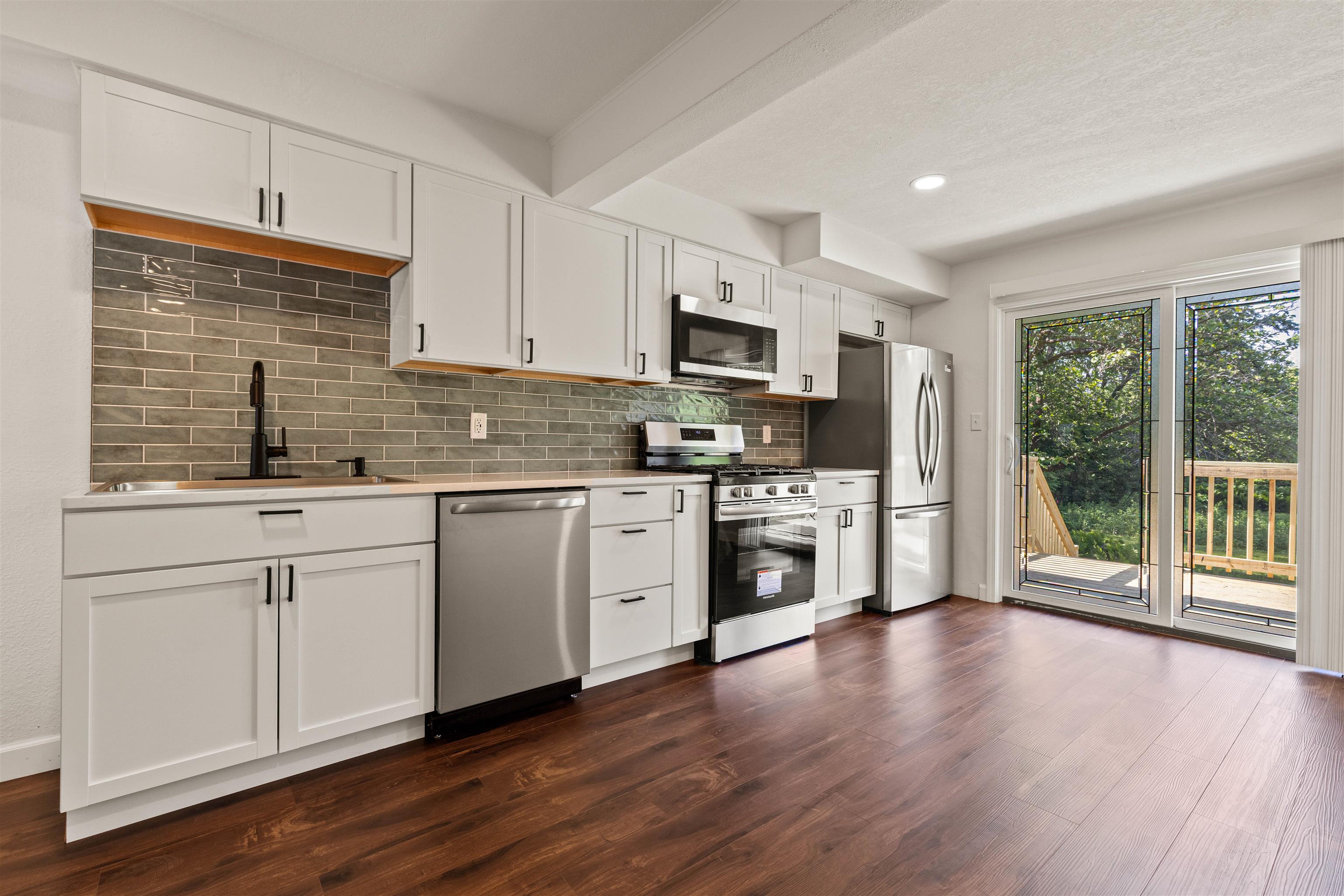 7330 Olde Creek Road Rockford, IL 61114 - Photo 11 of 20 a kitchen with stainless steel appliances white cabinets a sink a stove a refrigerator and a microwave