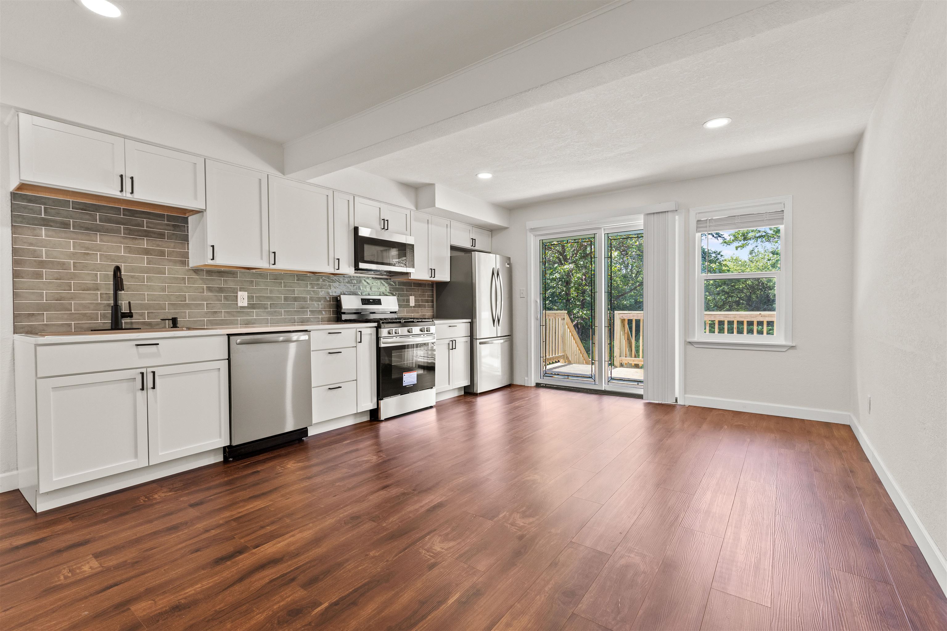 7330 Olde Creek Road Rockford, IL 61114 - Photo 7 of 20 a open kitchen with hard wood floors stainless steel appliances a sink and a window
