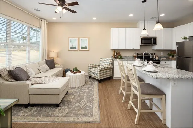 a living room with furniture a wooden floor and a chandelier