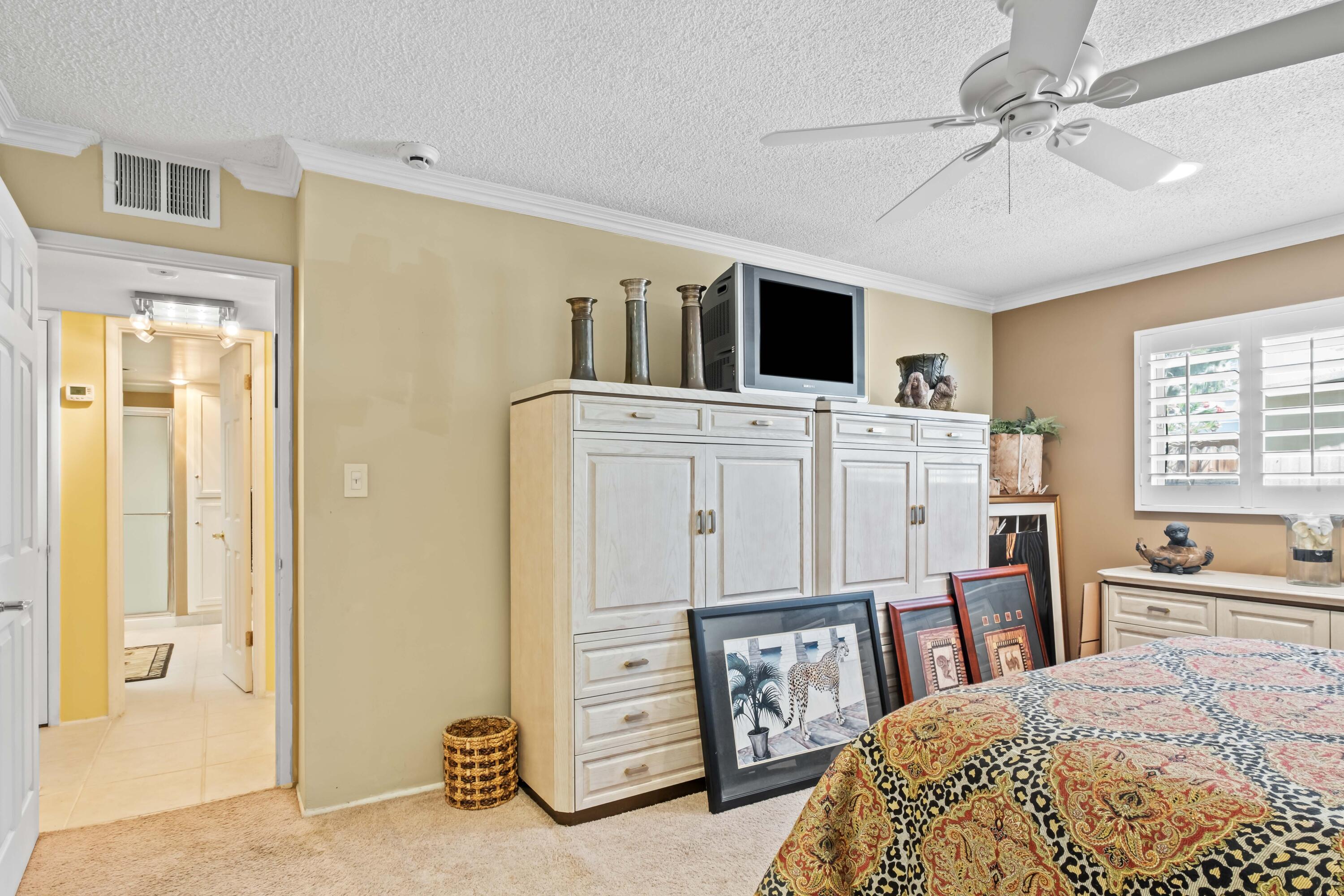 74460 Fairway Drive Palm Desert, CA 92260 - Photo 22 of 36 a bedroom with a bed a dresser and a chandelier