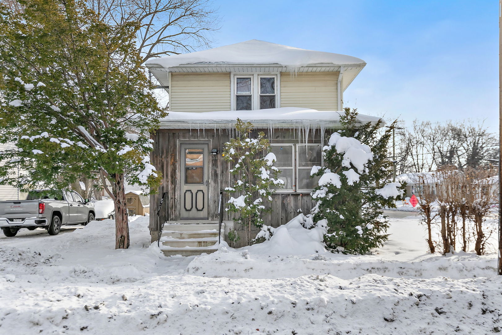 a front view of a house with a yard and tree s