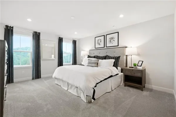 a spacious bedroom with a bed and a lamp