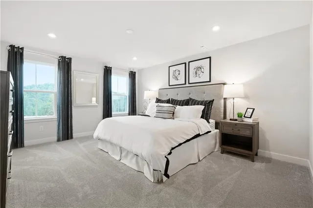 a spacious bedroom with a bed and a lamp