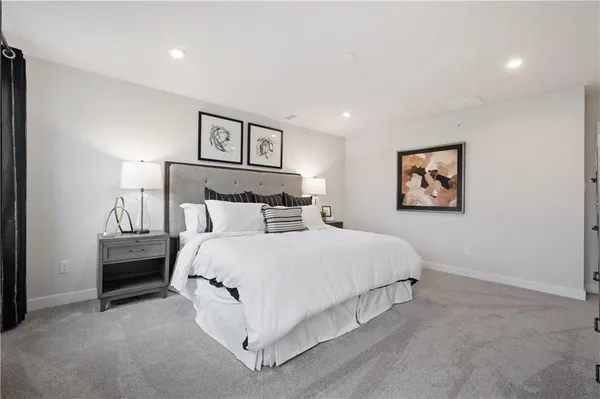 a spacious bedroom with a bed and painting on the wall