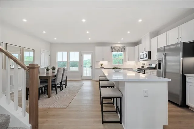 a kitchen with counter space dining table and stainless steel appliances