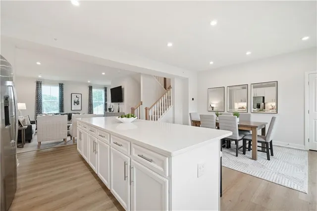 a large white kitchen with lots of counter space and furniture