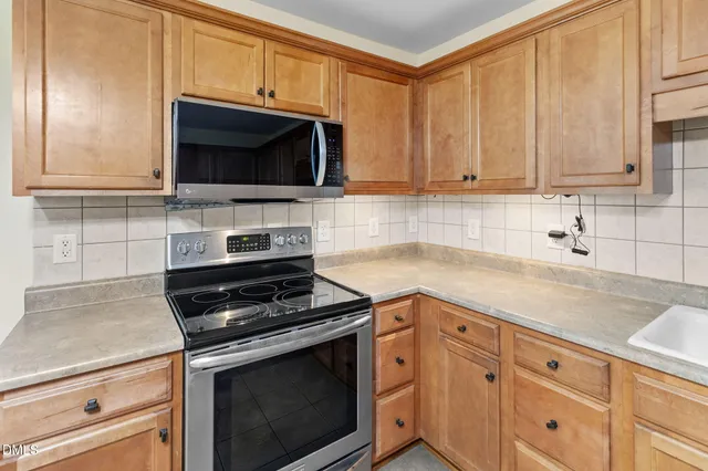 a kitchen with granite countertop white cabinets and black appliances