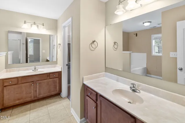 a bathroom with a sink double vanity granite tub shower and a mirror