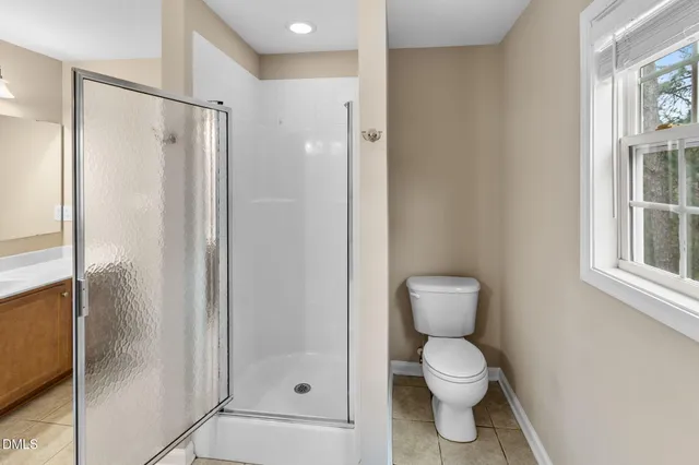 a bathroom with a toilet and a shower