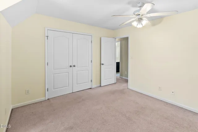 an empty room with chandelier fan