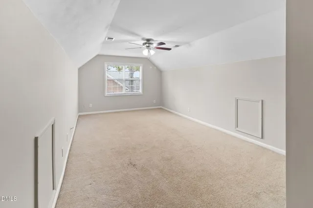 an empty room with a window and a ceiling fan