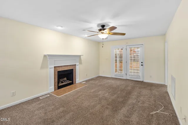 an empty room with windows and fireplace