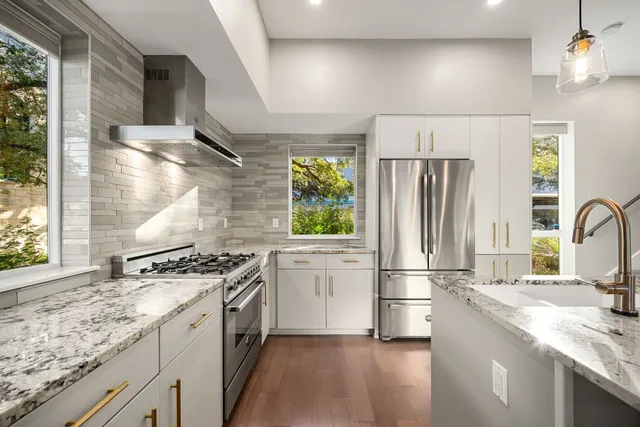 a kitchen with kitchen island a refrigerator and a stove