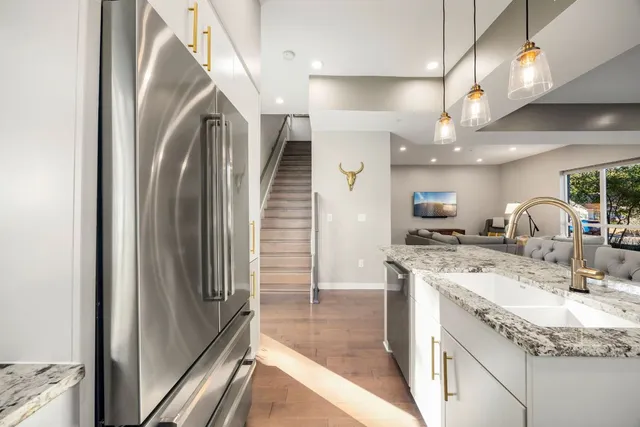 a kitchen with stainless steel appliances granite countertop a sink stove and refrigerator