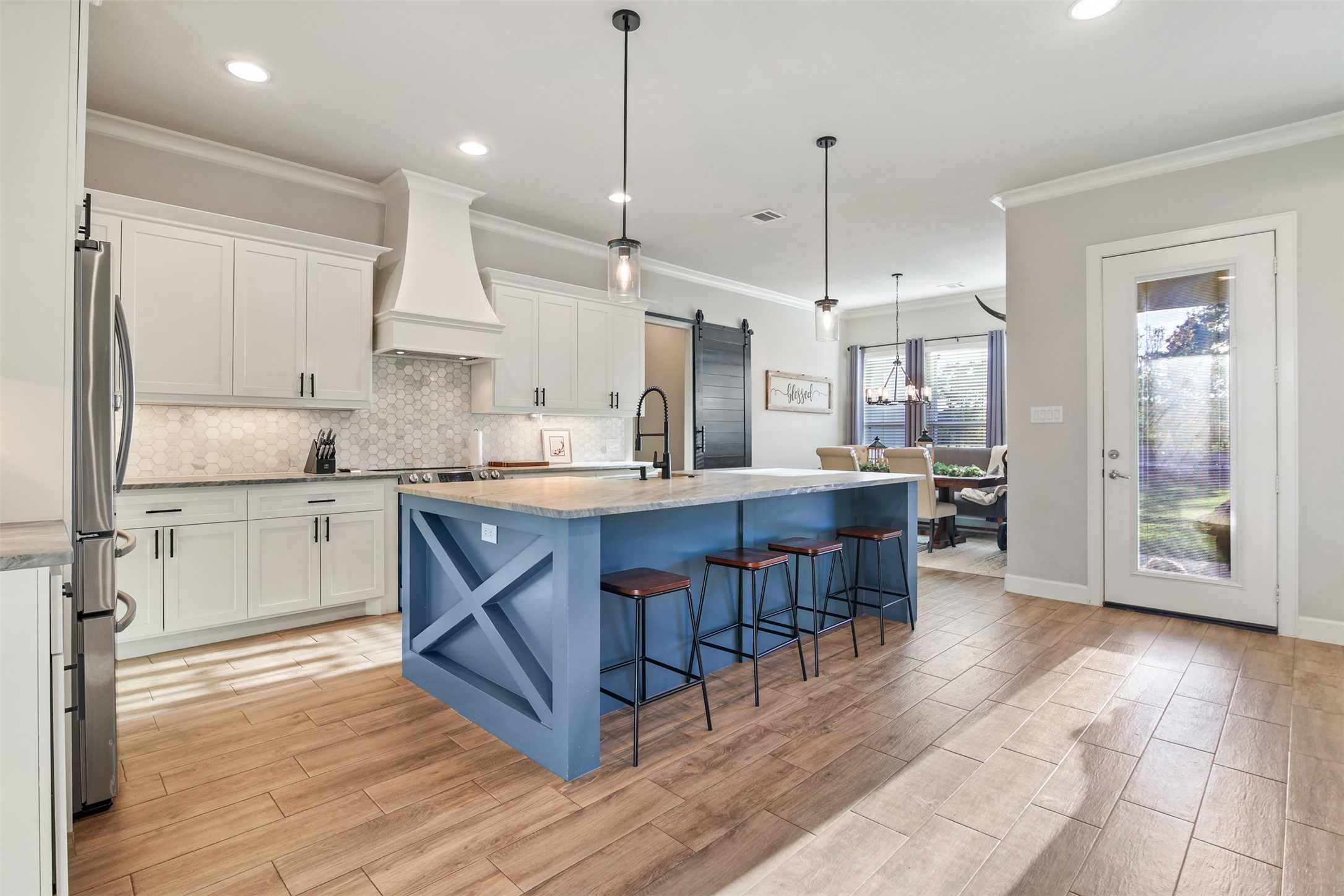 4219 Cross Cut Cleveland, TX 77328 - Photo 8 of 34 a open kitchen with stainless steel appliances granite countertop a refrigerator a sink dishwasher a stove and white cabinets with wooden floor
