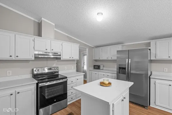 a kitchen with refrigerator cabinets and wooden floor