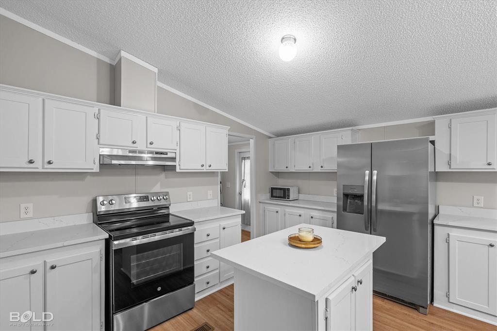 171 7 Pines Road Benton, LA 71006 - Photo 11 of 39 a kitchen with refrigerator cabinets and wooden floor