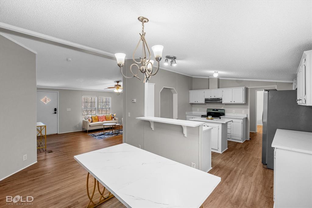 171 7 Pines Road Benton, LA 71006 - Photo 14 of 39 a open kitchen with cabinets a sink dishwasher a stove and a refrigerator with wooden floor
