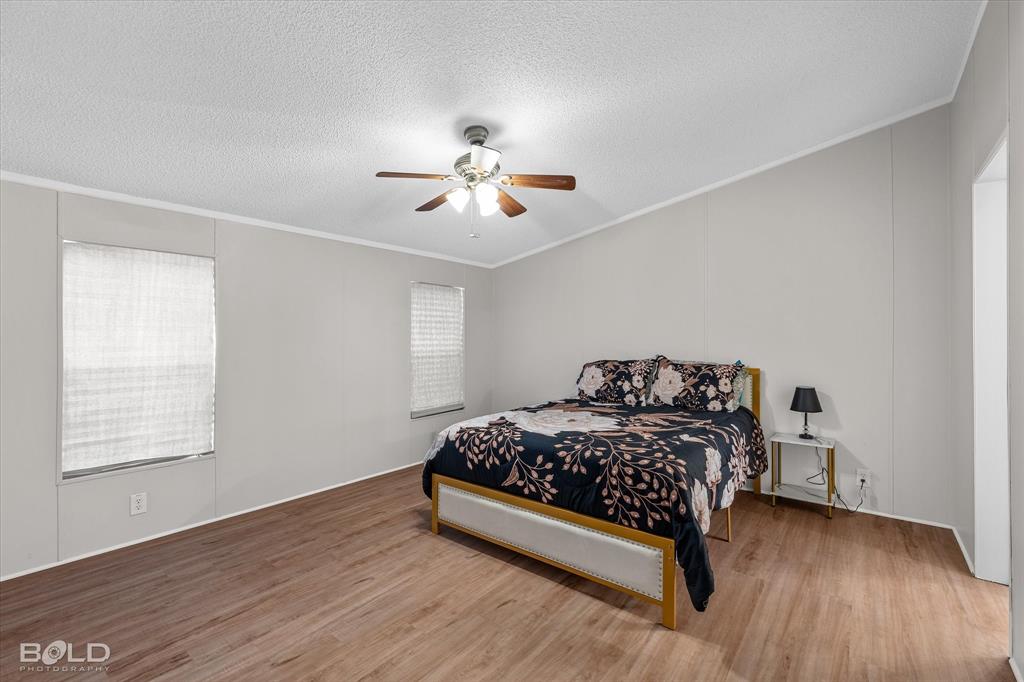 171 7 Pines Road Benton, LA 71006 - Photo 16 of 39 a bedroom with a bed and a chandelier