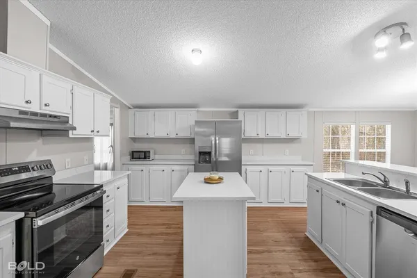 a kitchen with stainless steel appliances a stove sink microwave and cabinets