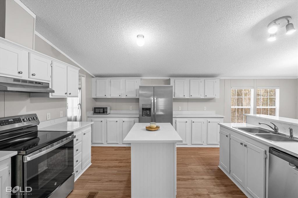 171 7 Pines Road Benton, LA 71006 - Photo 9 of 39 a kitchen with stainless steel appliances a stove sink microwave and cabinets