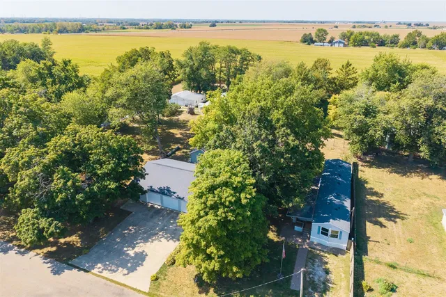 an aerial view of residential houses with outdoor space and trees
