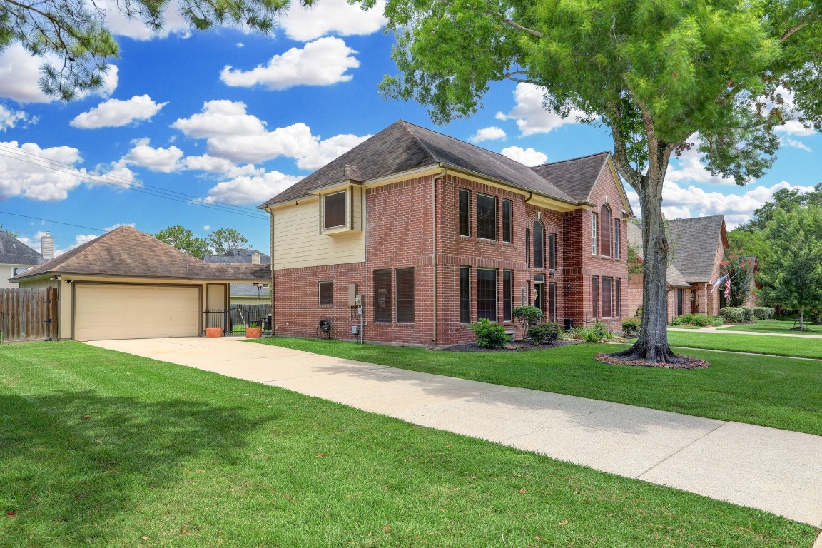 Established neighborhood in Friendswood ISD! View of the long driveway and detached 2 car garage.