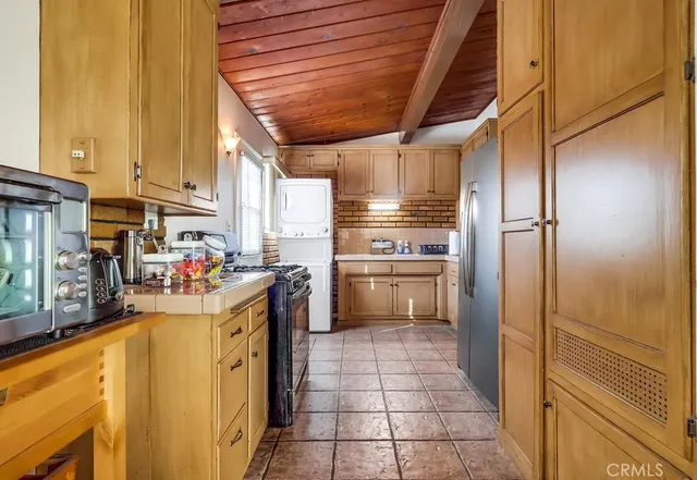 a kitchen with granite countertop a sink and a stove with wooden cabinets