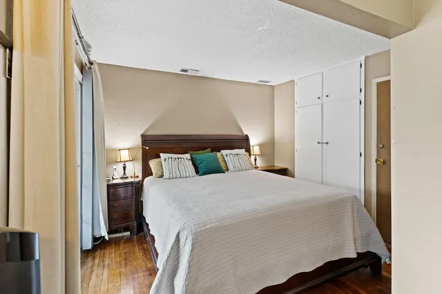 a bedroom with a bed and wooden floor