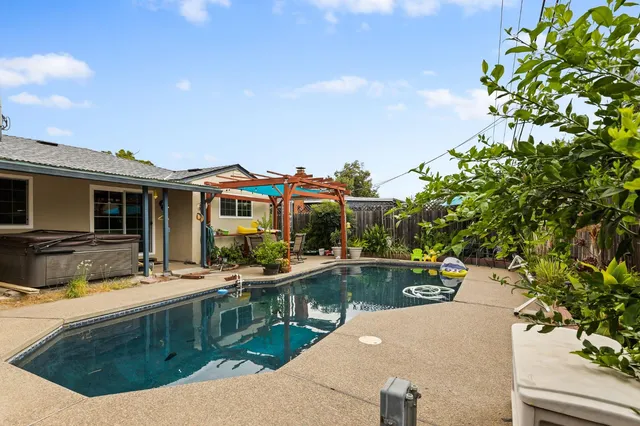 a view of a house with swimming pool and sitting area