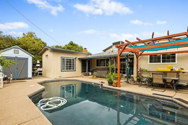 a view of a house with swimming pool and sitting area